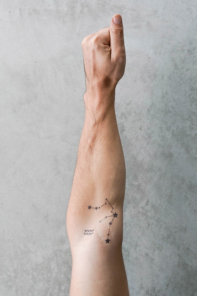 Aquarius tattoo on a forearm with a zodiac constellation and wave symbols