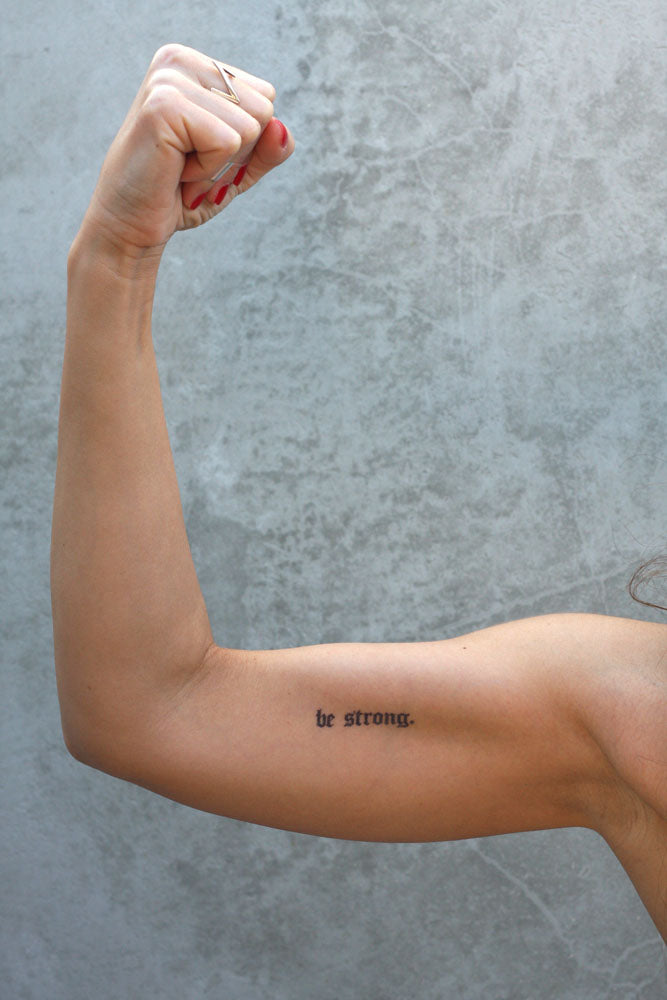 "Be Strong" temporary tattoo on a person's bicep