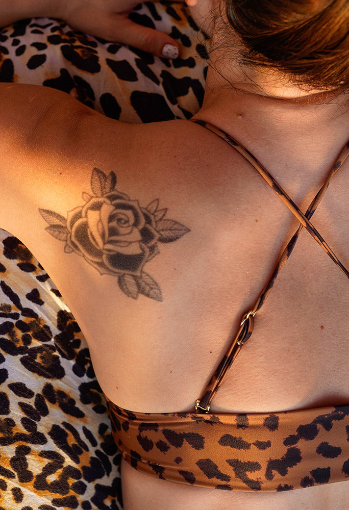 Person with a rose tattoo on the upper back