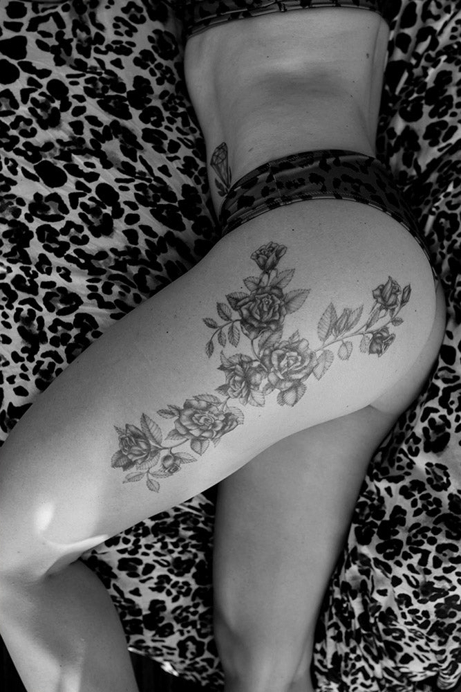 Person's thigh and hip with black roses temporary tattoo