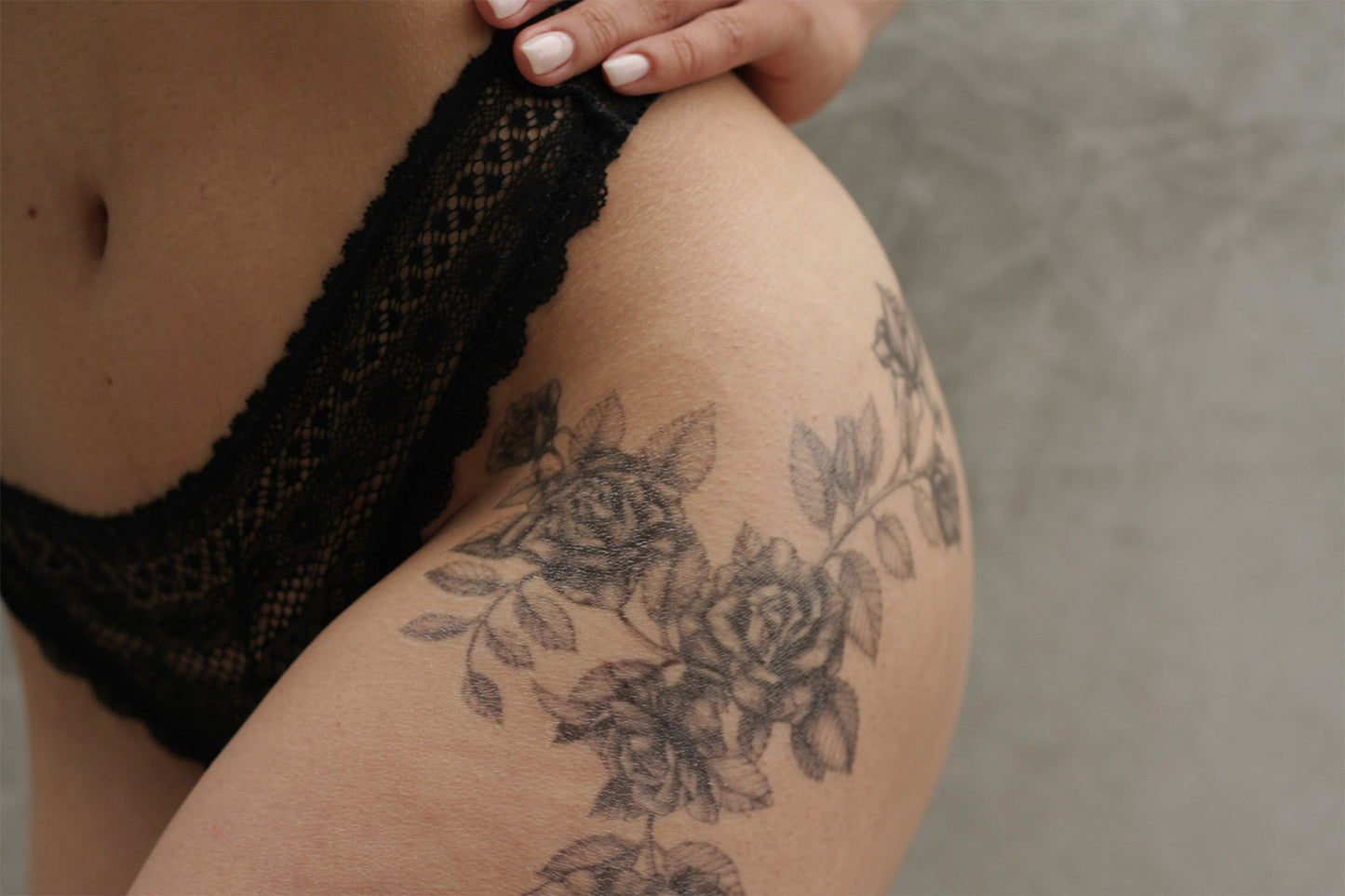 Black roses temporary tattoo on a person's upper thigh and hip
