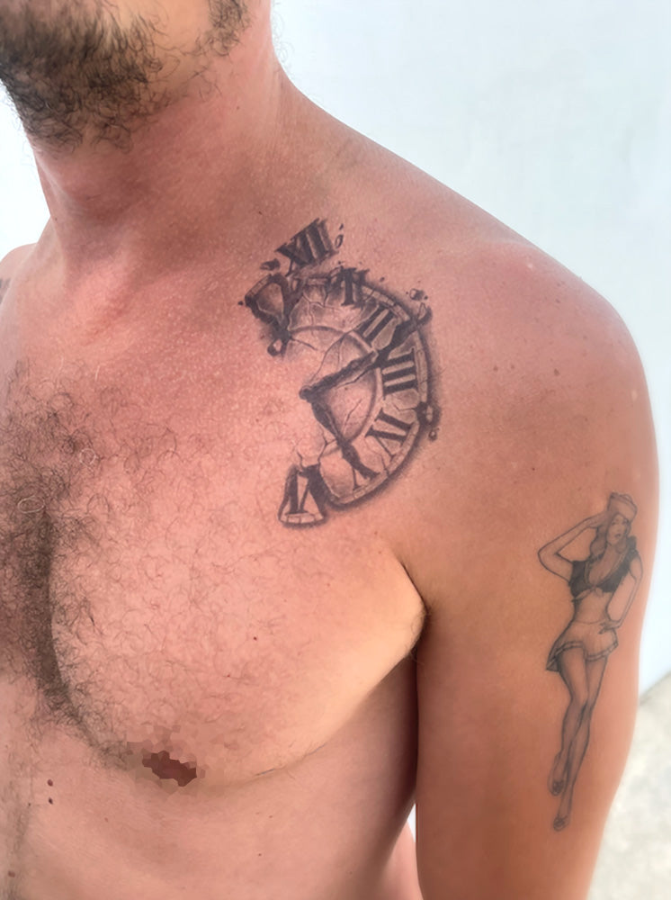 Person with a realistic tattoo of a broken clock on the chest
