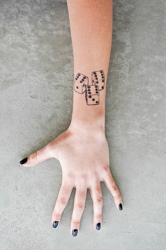 A person's arm with a 666 Dice temporary tattoo