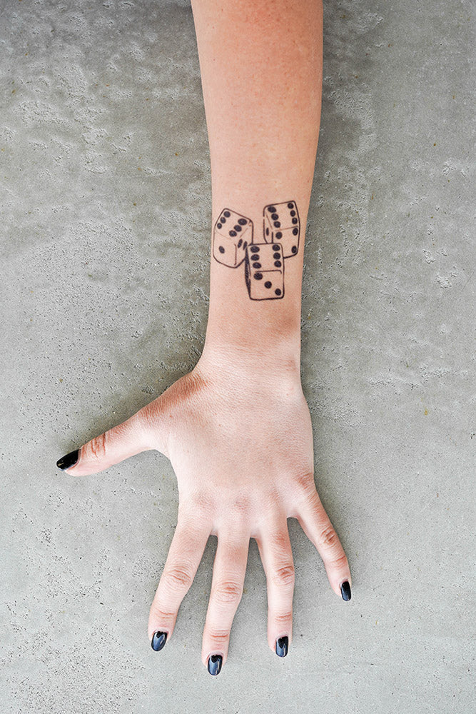 A person's arm with a 666 Dice temporary tattoo