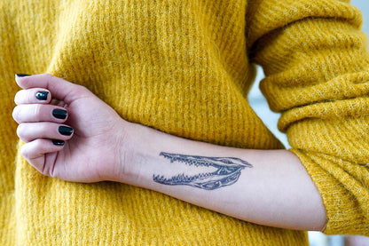 A person showing off a high-quality Alligator Skull Dotwork temporary tattoo on their forearm