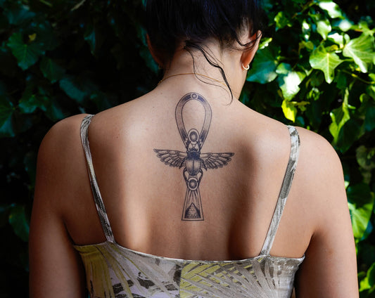 A person with a large mystical ankh tattoo on their upper back