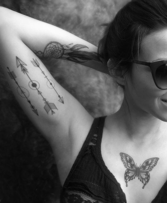 A person with detailed arrow geometric temporary tattoos on their arm, reflecting a tribal spirit