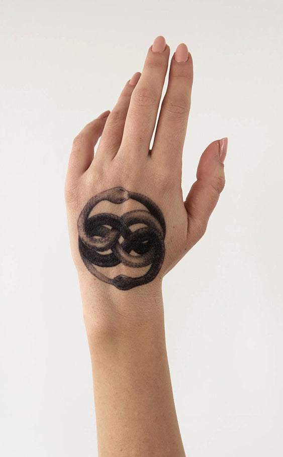 A hand with an Auryn temporary tattoo, inspired by the powerful medallion from Michael Ende's book 'The NeverEnding Story'
