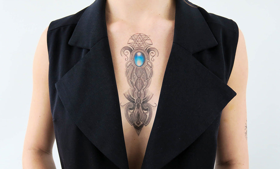 Person with a blue stone ornament tattoo on the chest