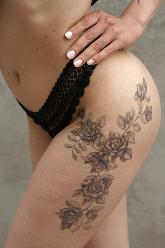 Black roses temporary tattoo on a person's upper thigh and hip